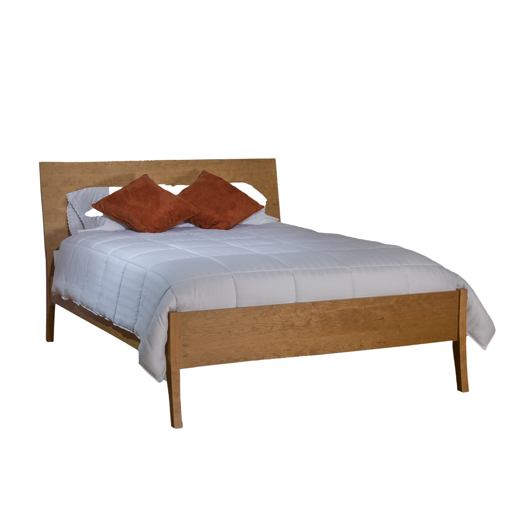 A wooden slanted panel bed with a low footboard, accompanied by two brown pillows on top of the bed.
