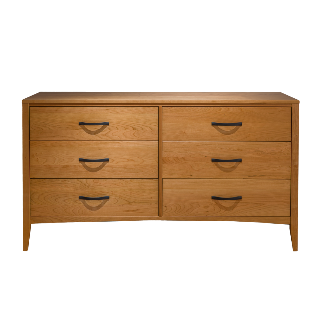 A natural solid cherry six-drawer dresser with a simple design and metal handles complimented by its traditional legs.